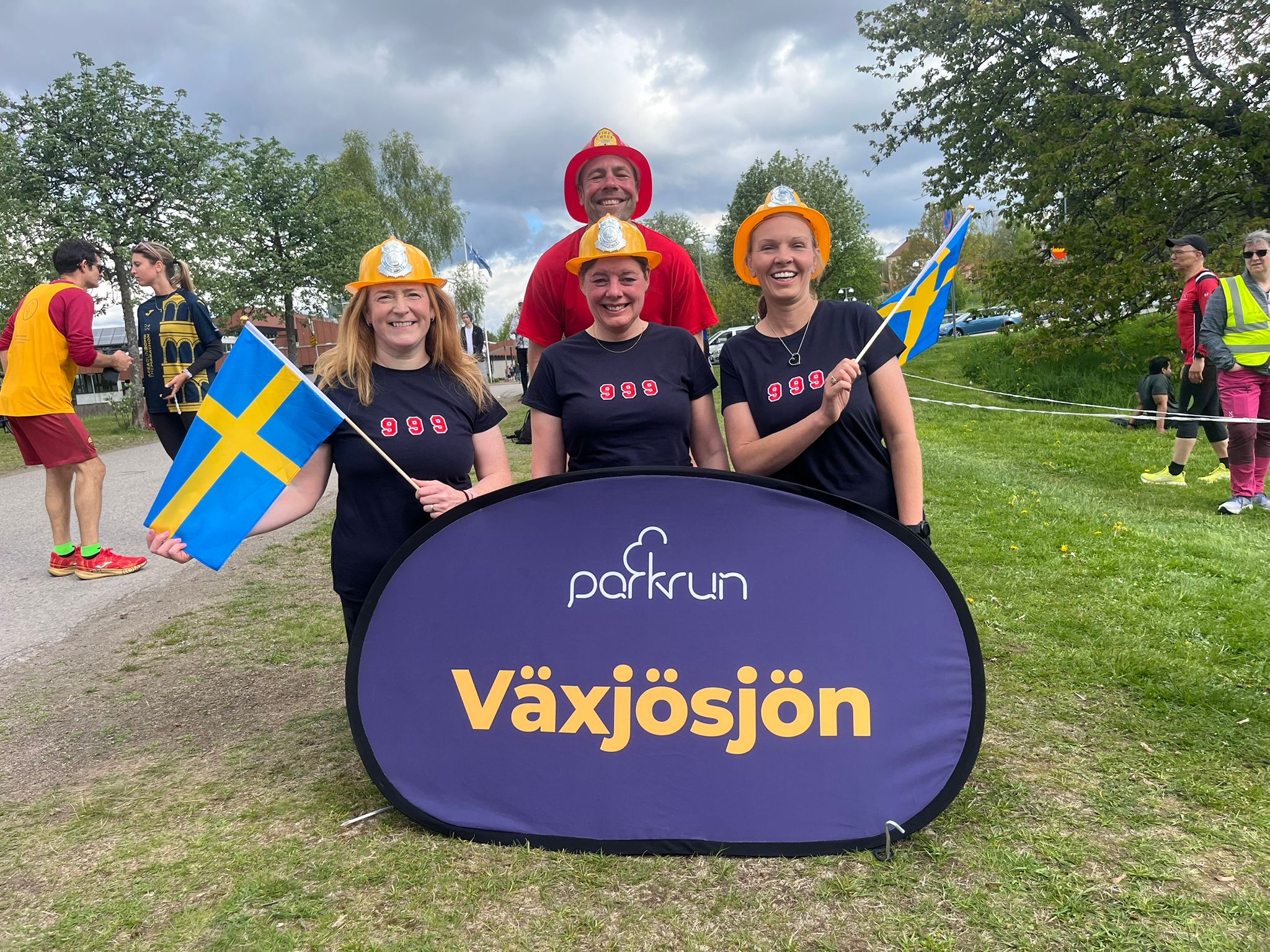 Darren Wood and friends wearing firefighter helmets in Sweden at his 999th parkrun