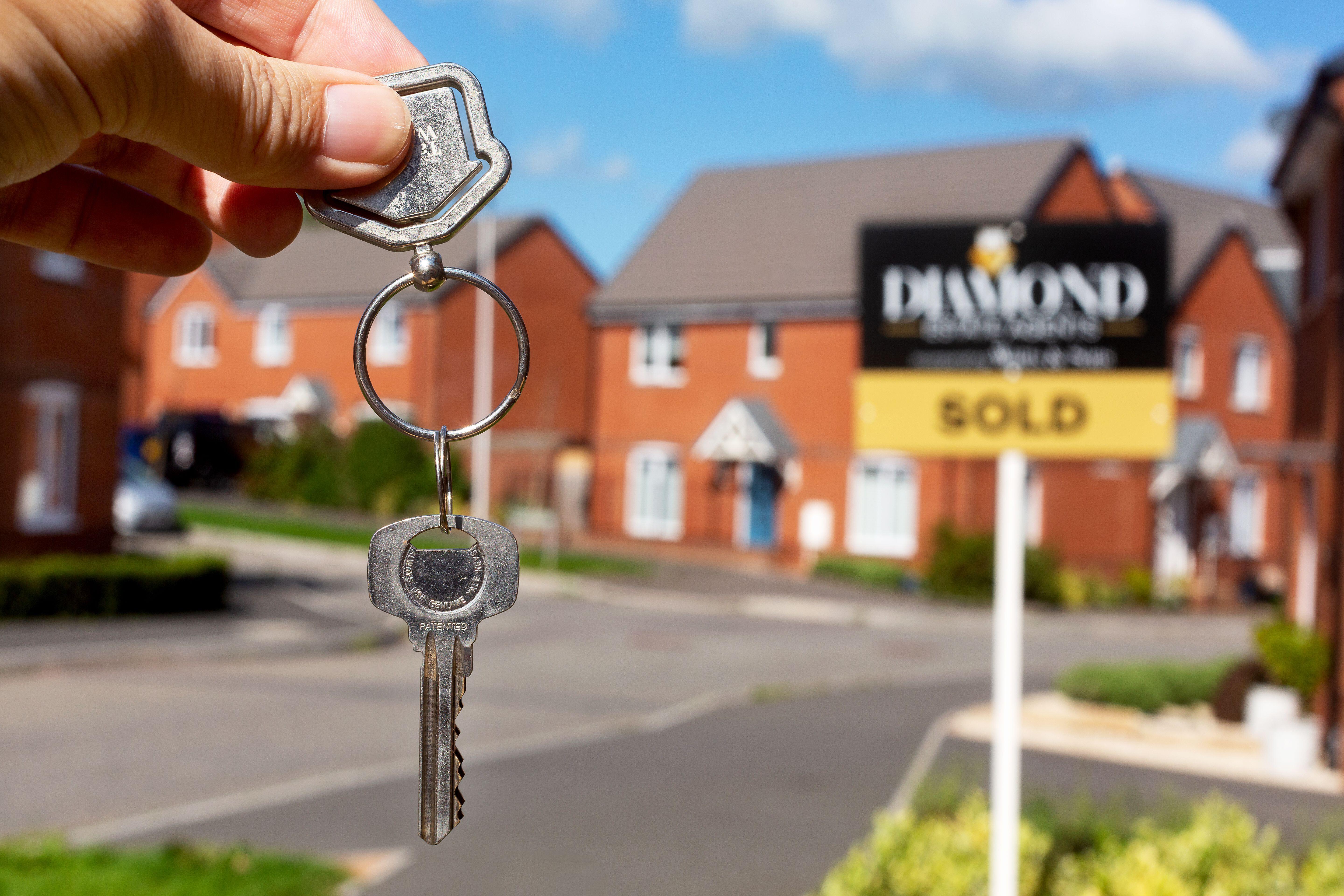 A new house buyer proudly shows off his house keys for a new house purchase