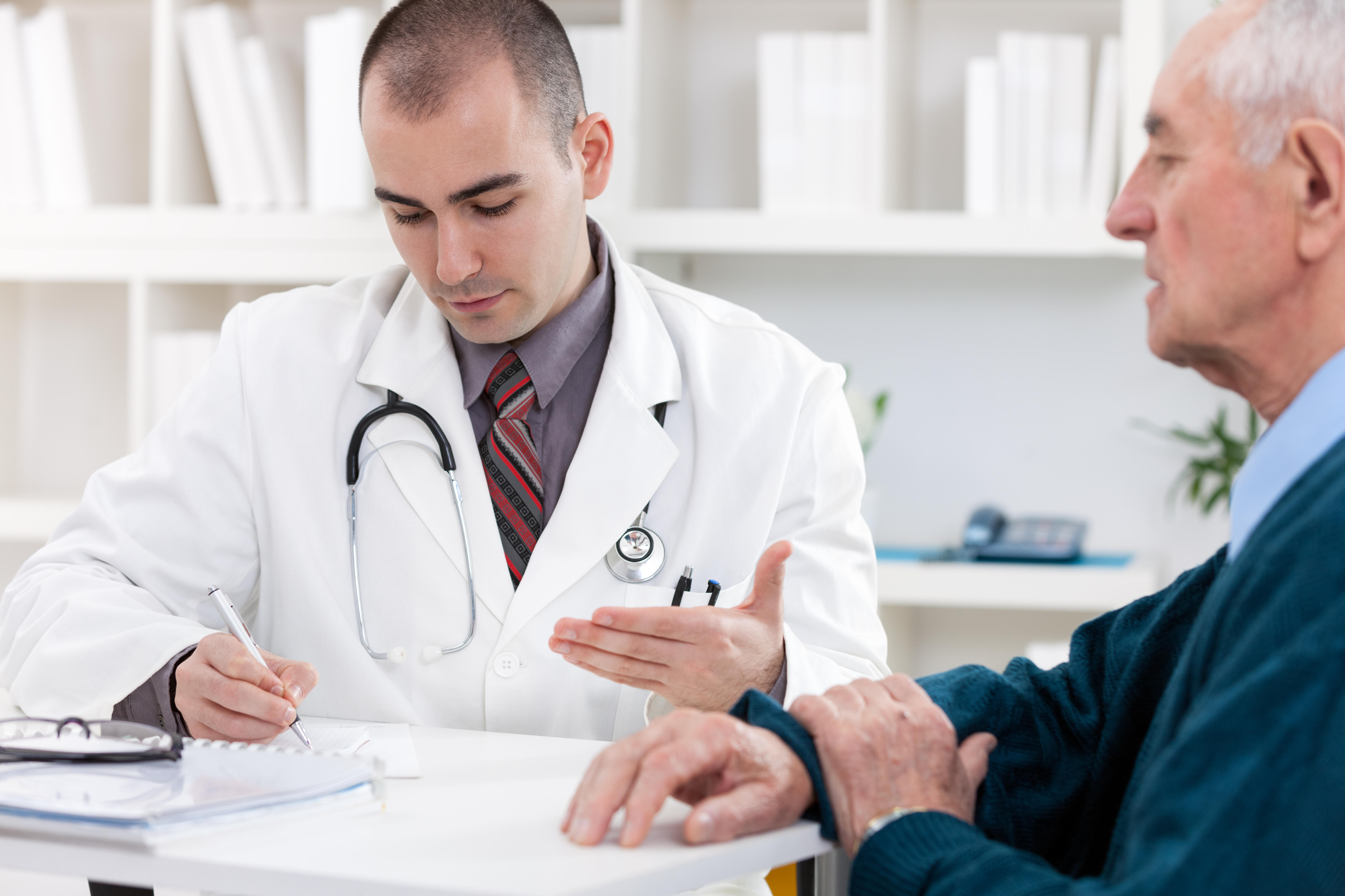 Portrait of handsome male doctor talking with senior patient