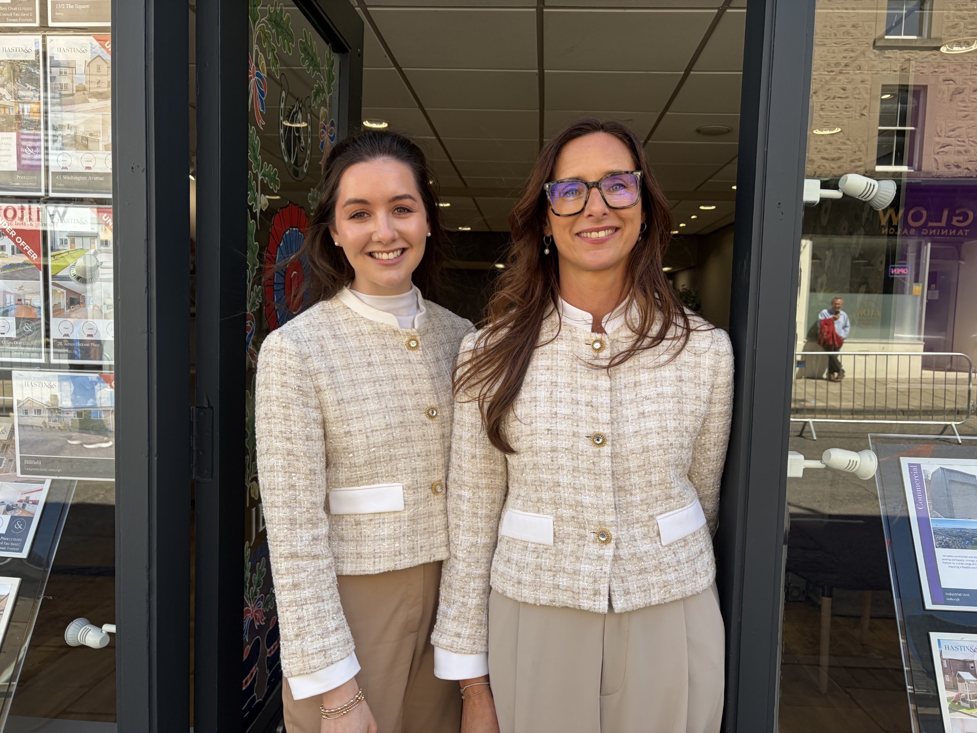 Jodi Gregg and Julie Gallagher smiling at the door of an estate agent shop