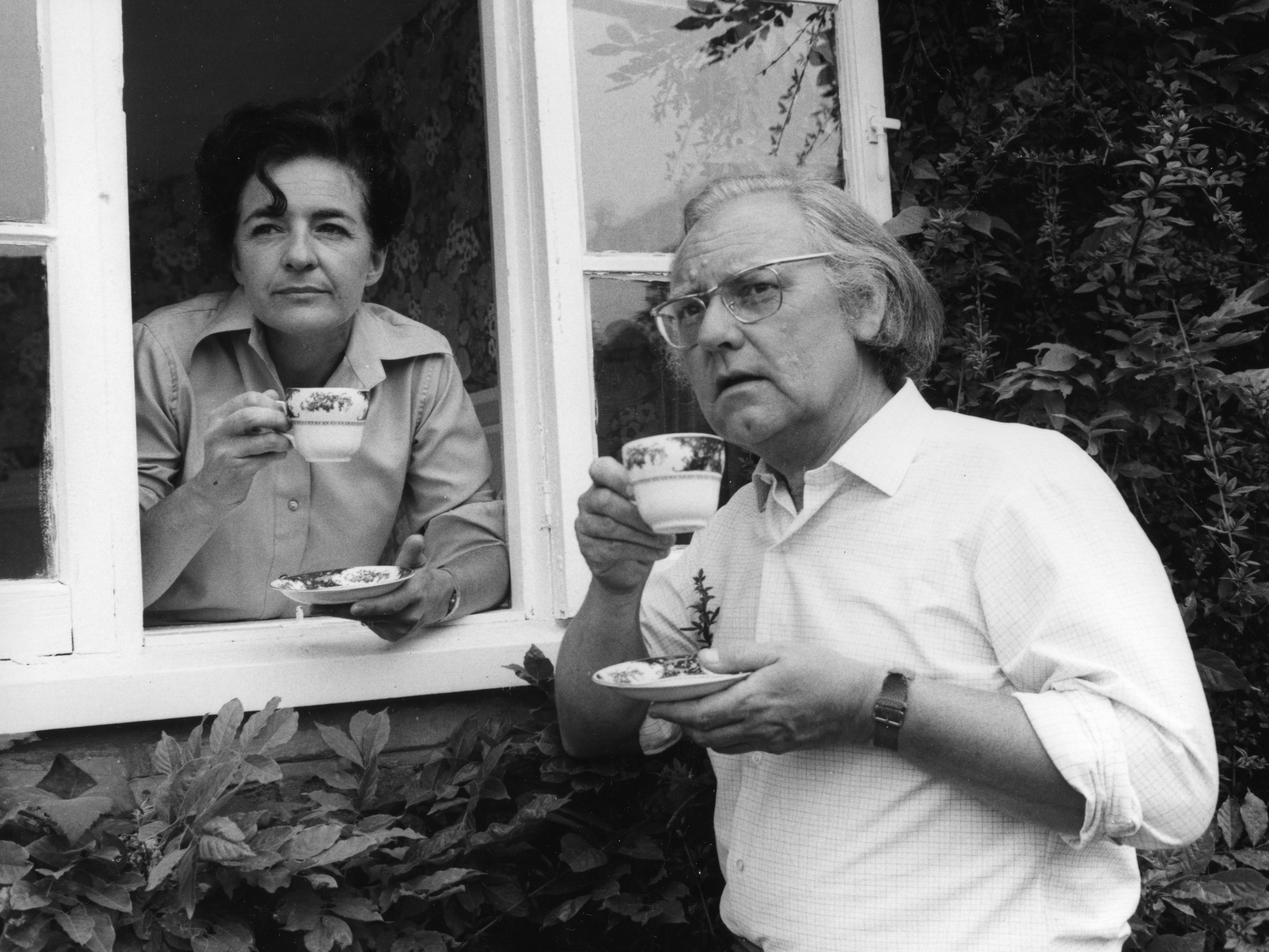Black and white photo of Patricia Greene and Norman Painting, who are both holding china cups