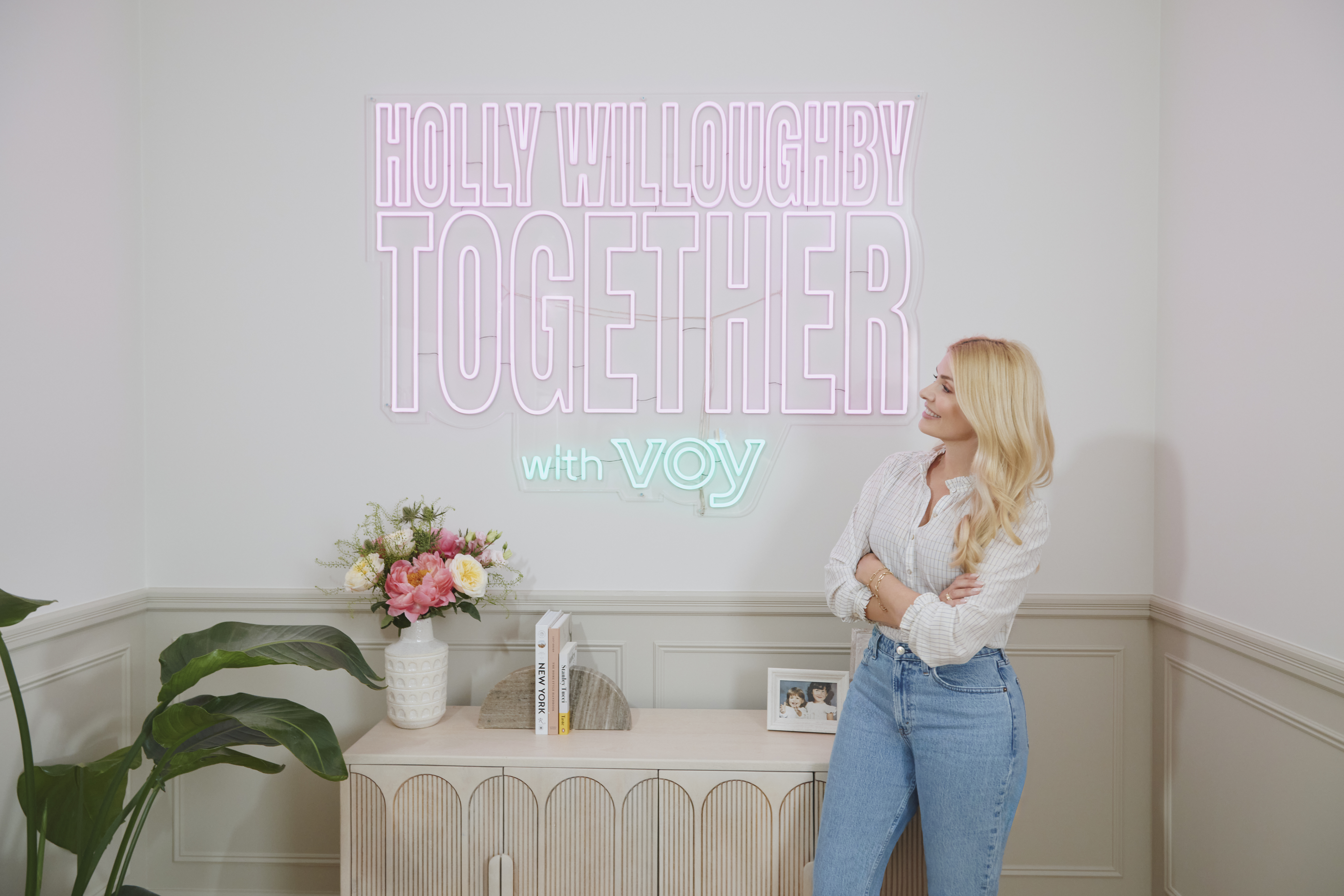 Holly Willoughby next to a Holly Willoughby Together illuminated sign