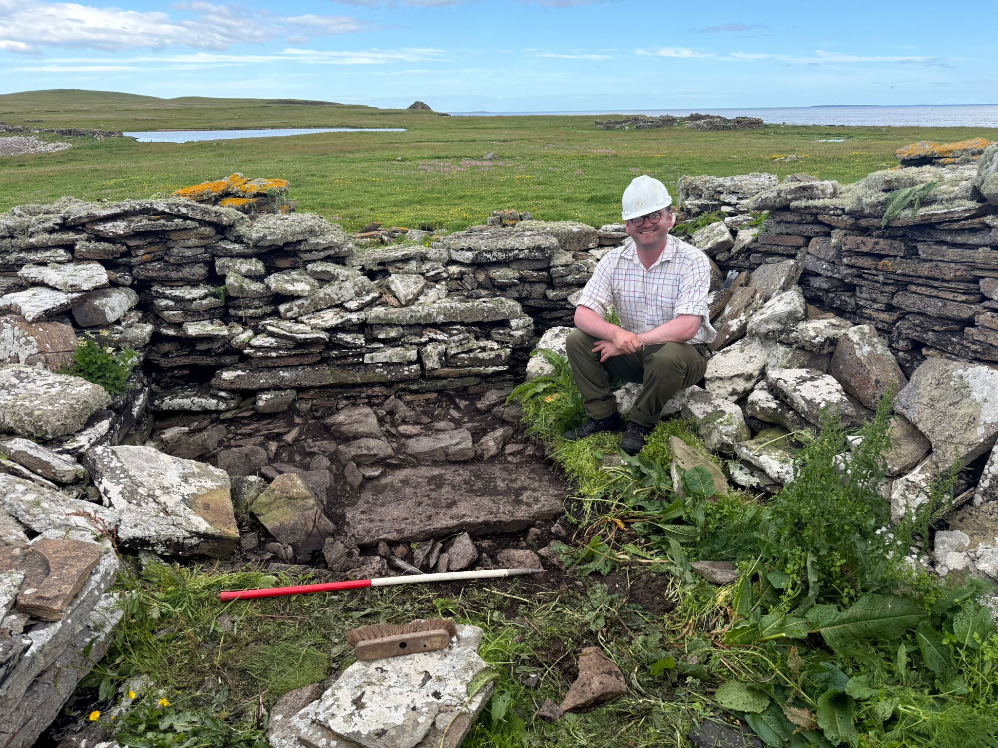 Dan McLean smiling while seated in a ruin