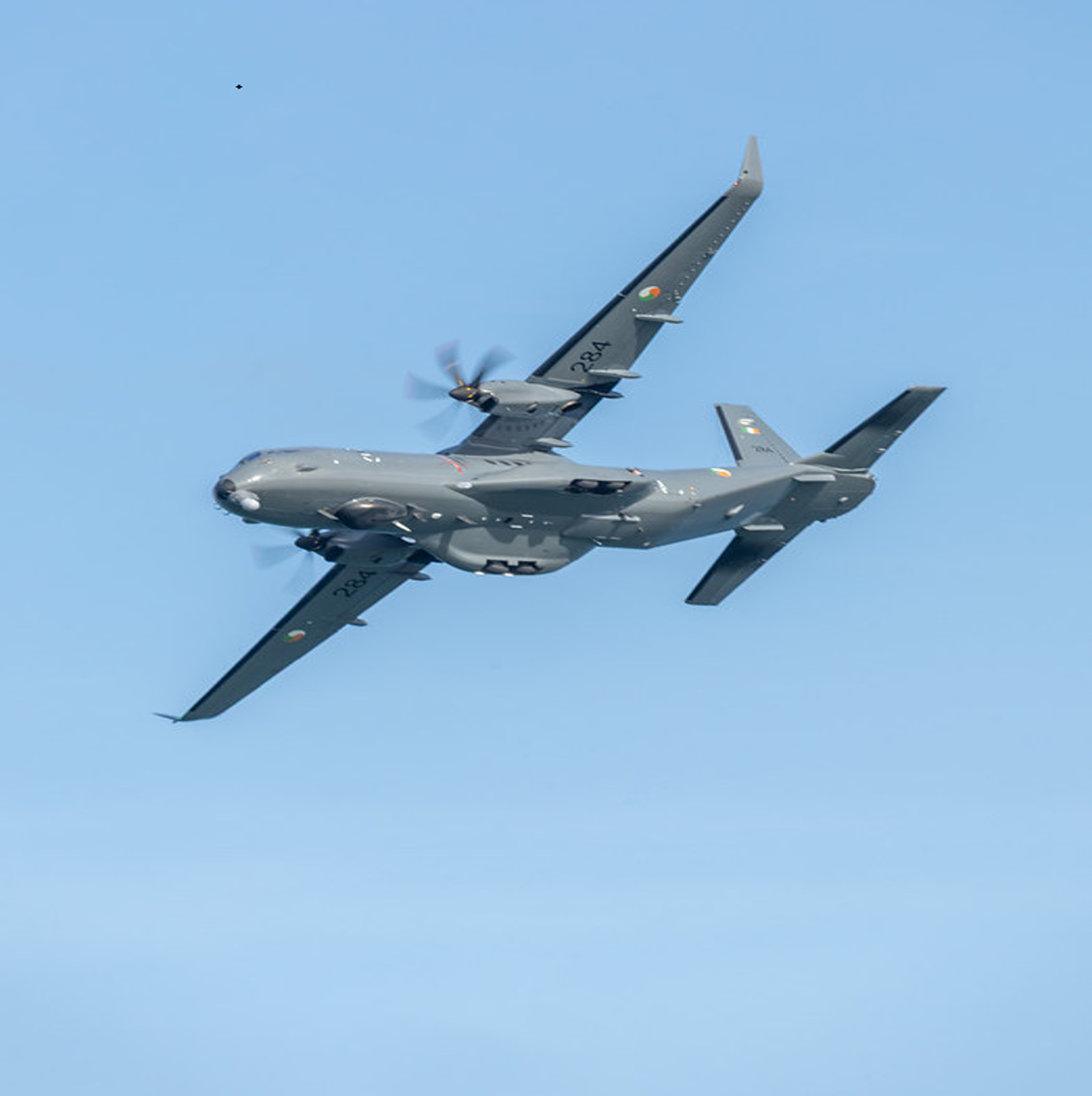 A C-295 aircraft flying in a blue sky