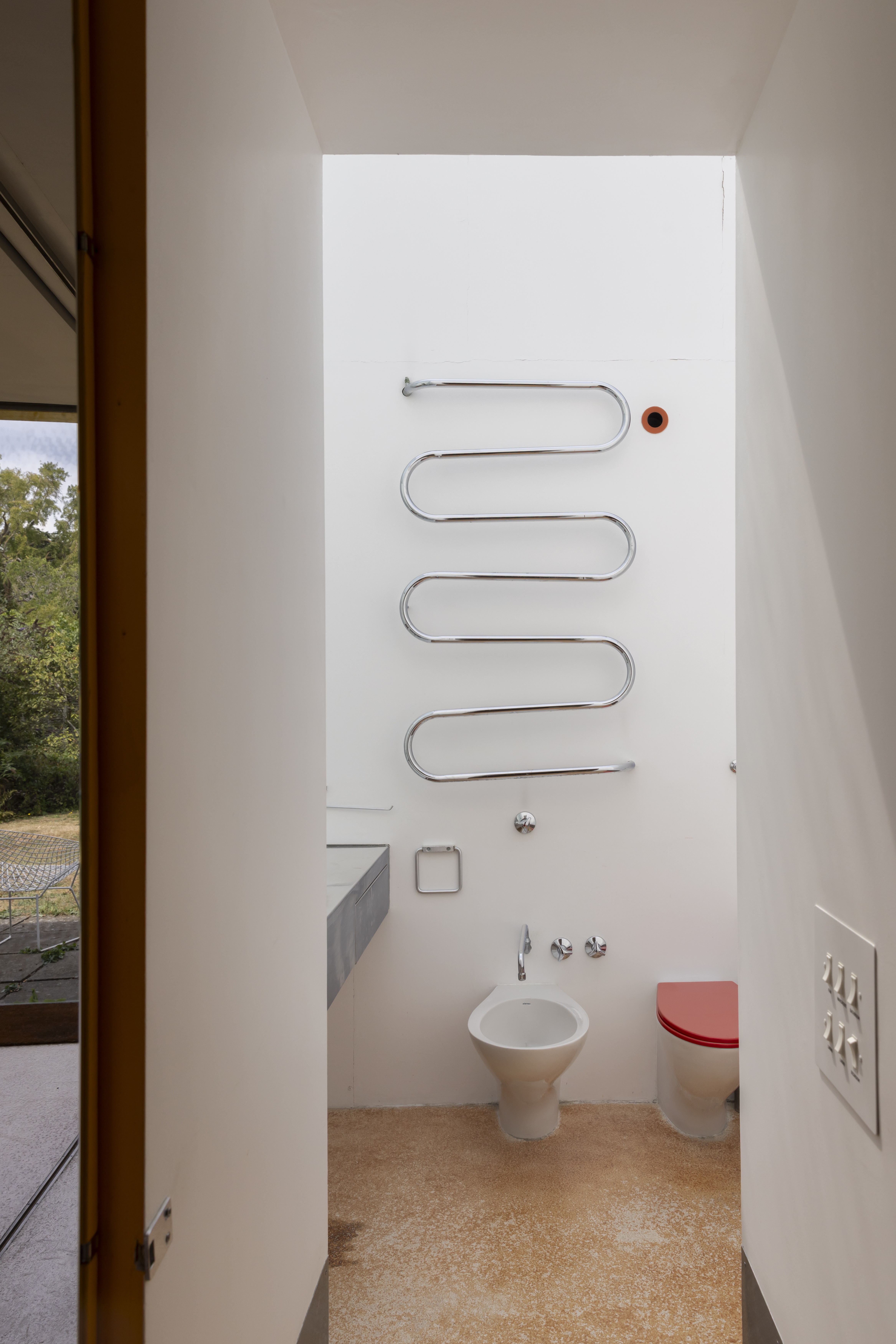 View of a curved radiator above a toilet