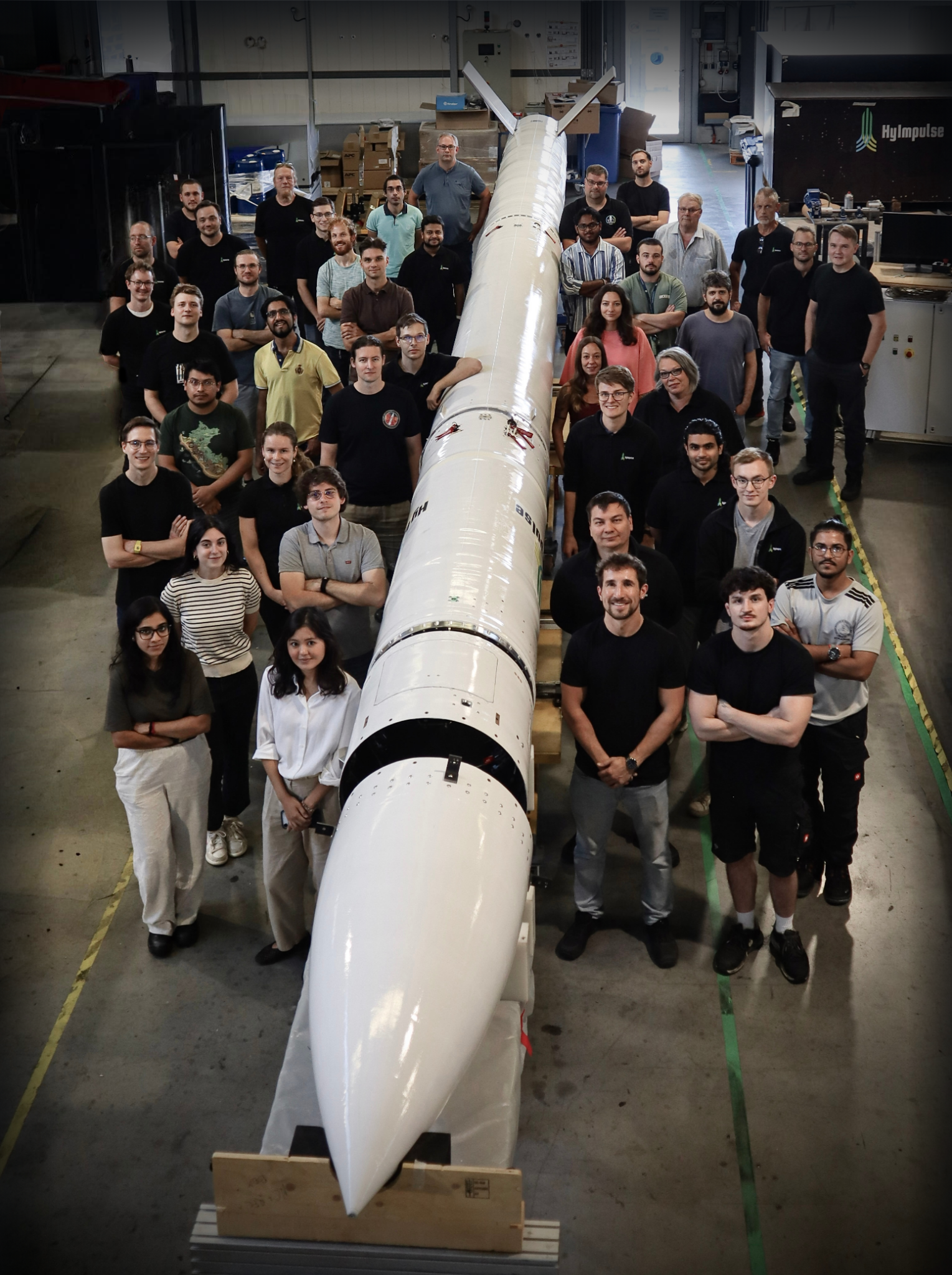 HyImpulse staff smiling, while posing for a photo alongside the SR75 rocket