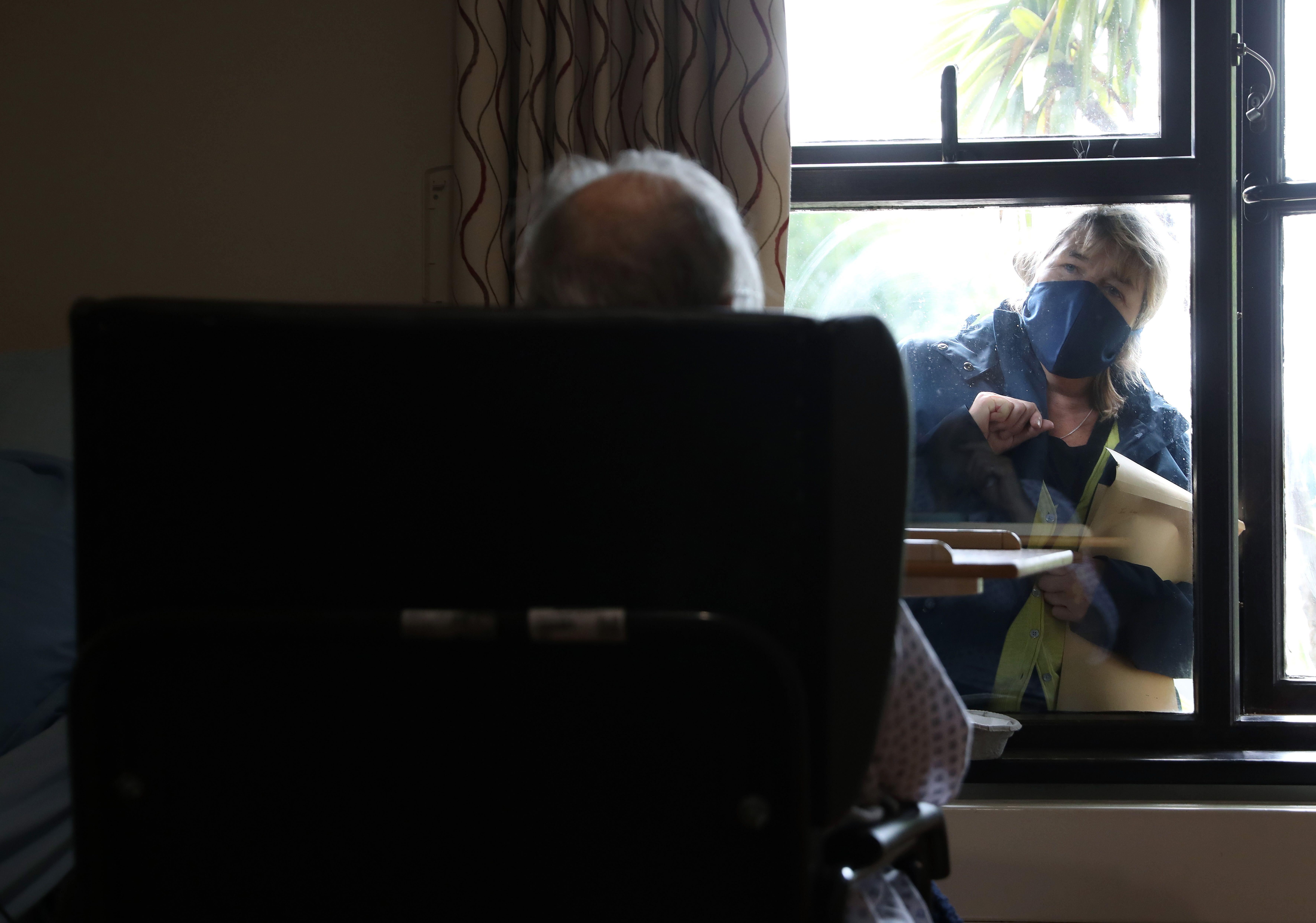 An elderly resident talks to a visitor through the window at nursing home in south London, as research has revealed that care home residents were more likely to die of Covid-19 in the UK than in any of the major European countries apart from Spain. Pictur