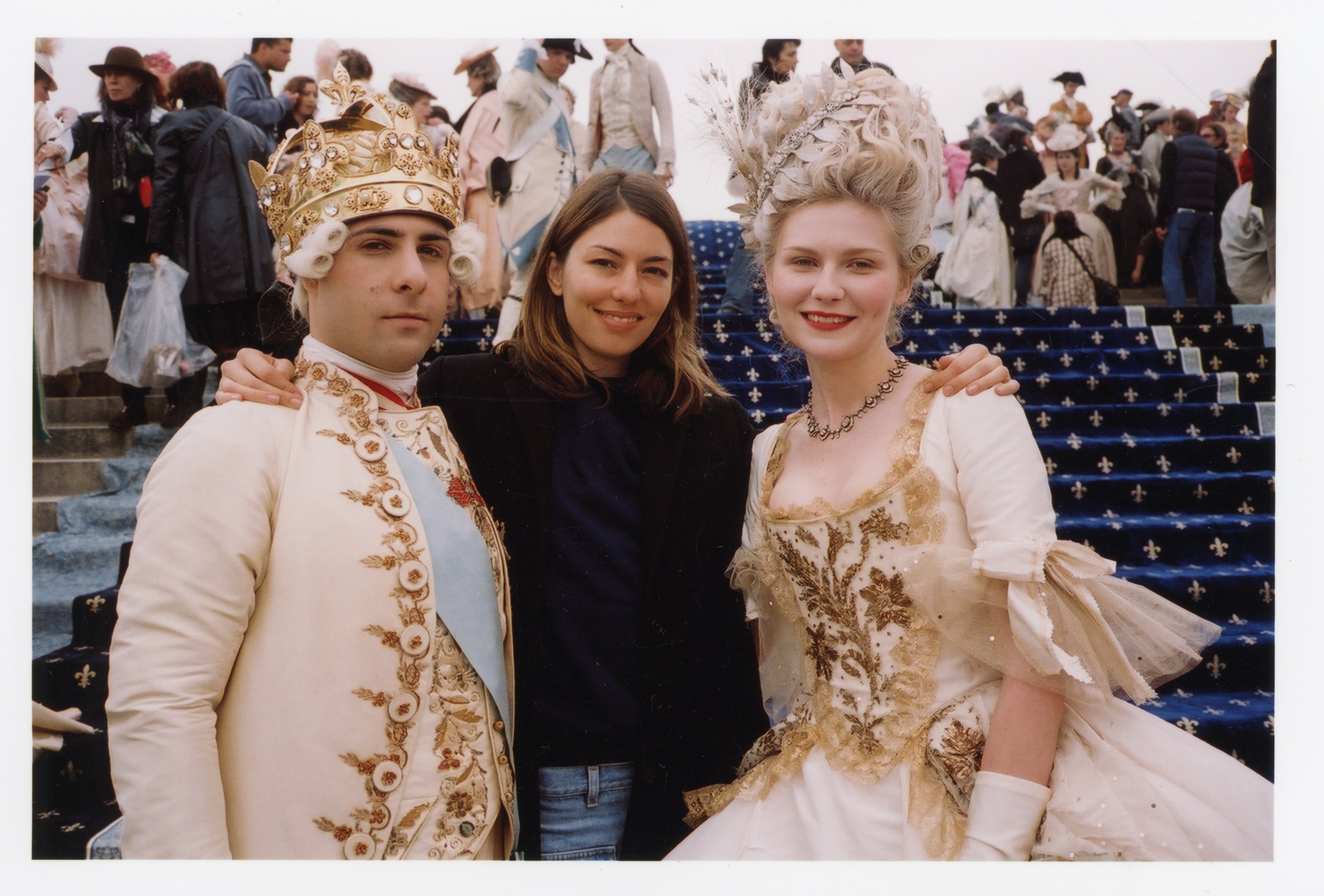 Jason Schwartzman and Kirsten Dunst in period dress, flanking Sofia Coppola on set