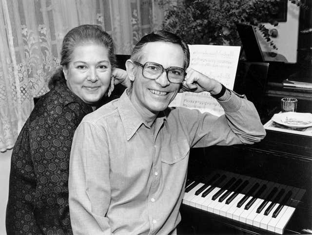 Marilyn and Alan Bergman pose at a piano in their home