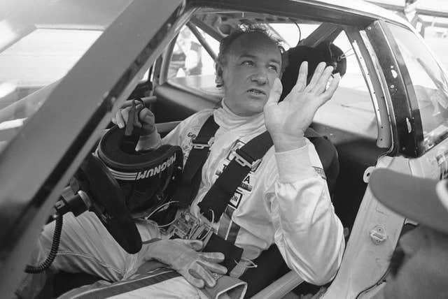 Actor Gene Hackman waves as he starts out for a practice run in his Toyota Celica in 1983