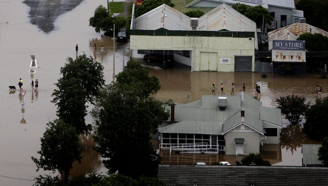 People wade through floodwaters in the town of Moree, northern New South Wales, Australia