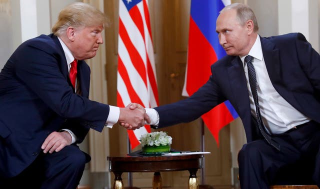 Donald Trump shakes hands with Vladimir Putin