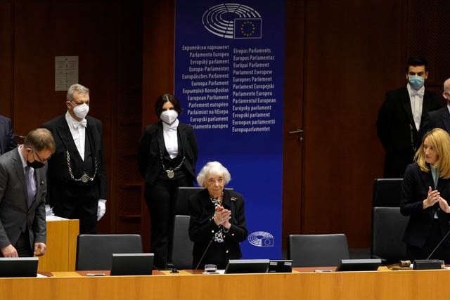 Holocaust survivor Margot Friedlander, centre, stands as members of the European Parliament applaud after an address in the plenary chamber at the European Parliament in Brussels in 2022