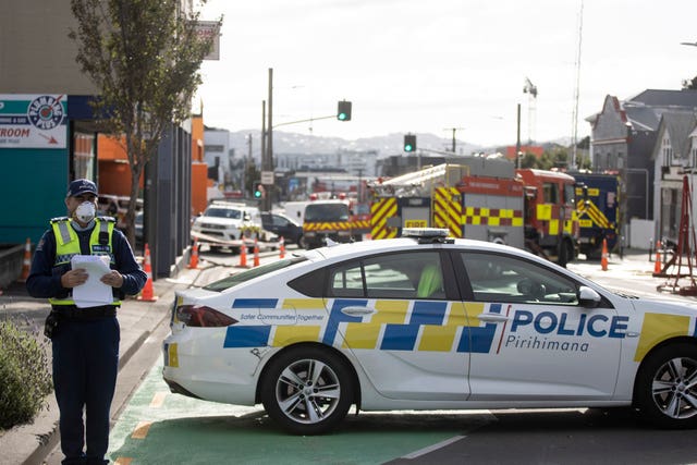 Investigators survey the scene after a fire at Loafers Lodge in Wellington, New Zealand