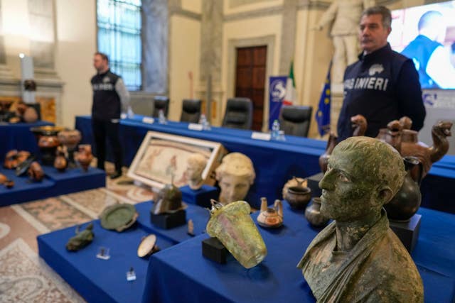 A bronze male bust, dated between the first century BC and the first century AC is seen in foreground among 60 archaeological artefacts stolen from Italy and sold in the US by international art traffickers, during a press conference in Rome
