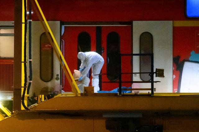 Investigators in white protective suits work in the regional train that had been driven on to a siding in Neumunster, Germany