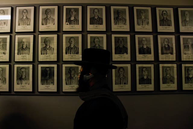 An orthodox Jew walks past the portraits of victims at the former Nazi German concentration and extermination camp Auschwitz-Birkenau in Oswiecim, Poland