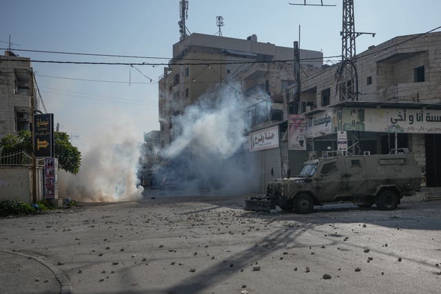 Palestinians clash with Israeli forces following an army raid in the West Bank city of Jenin