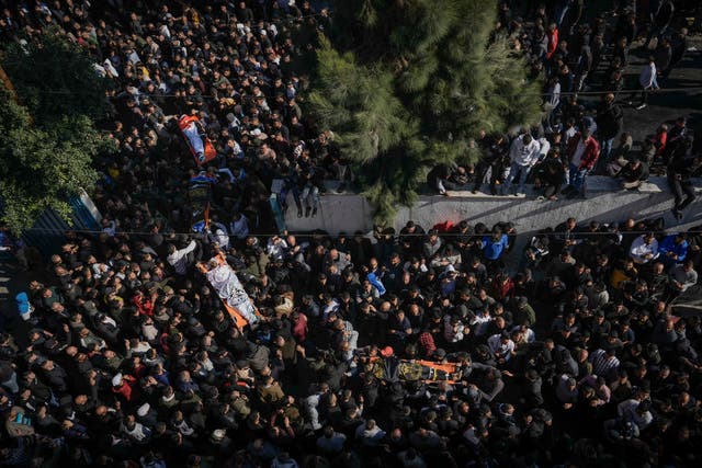 Mourners carry the bodies of eight Palestinians, some draped in the flag of the Islamic Jihad militant group, during a joint funeral in the West Bank city of Jenin
