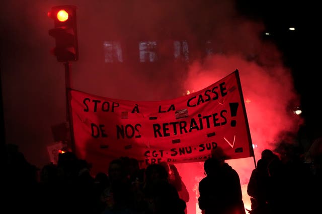 Protesters hold a banner demanding to stop plans to push back France’s retirement age, during a demonstration in Paris