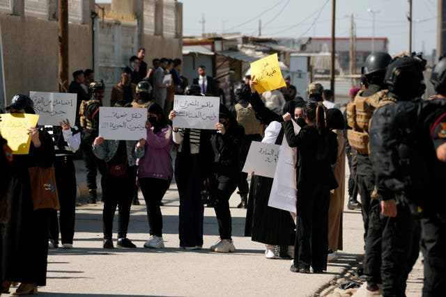 Demonstrators hold placards as they protest on the killing of Tiba Ali, a YouTube star who was recently killed by her father, in Diwaniya, Iraq