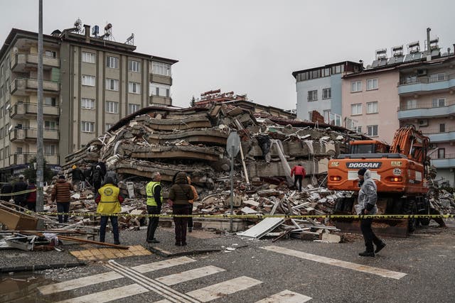 Emergency teams search for people in the rubble of a destroyed building