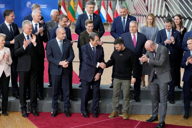 Ukraine’s President Volodymyr Zelensky, front centre right, shakes hands with Cypriot President Nicos Anastasiades as they pose with other European Union leaders during a group photo at an EU summit in Brussels