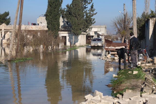 A car drives through a village in Syria which flooded after the earthquake