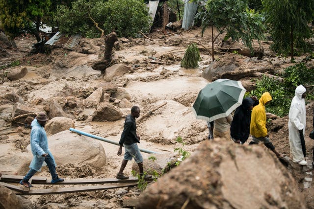 People cross a raging river in Blantyre, Malawi