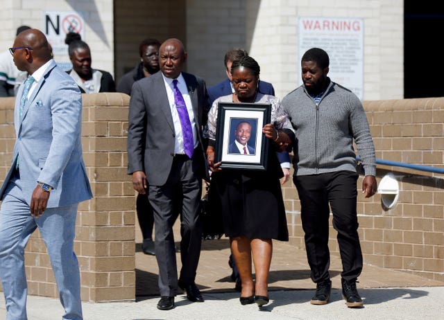 Irvo Otieno's mother Caroline Ouko holds a portrait of her son as she walks out of Dinwiddie Courthouse