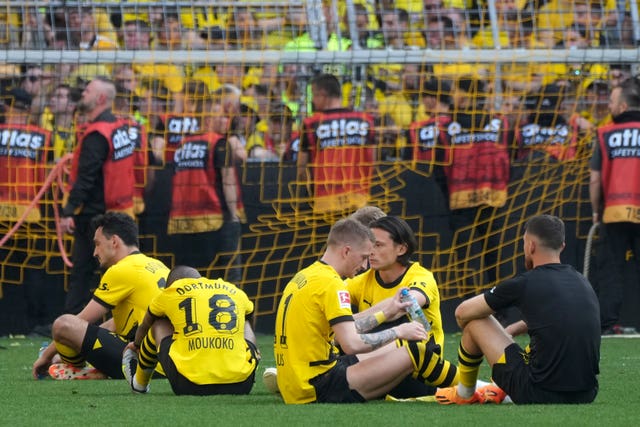 Dortmund’s players sit on the pitch after missing out on the title