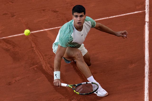 Carlos Alcaraz slides into a backhand