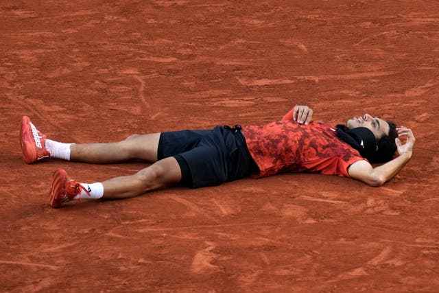 Francisco Cerundolo lies on the court after beating Taylor Fritz