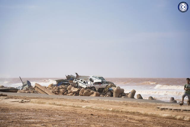 Cars sit piled on the sea bank in Derna, Libya