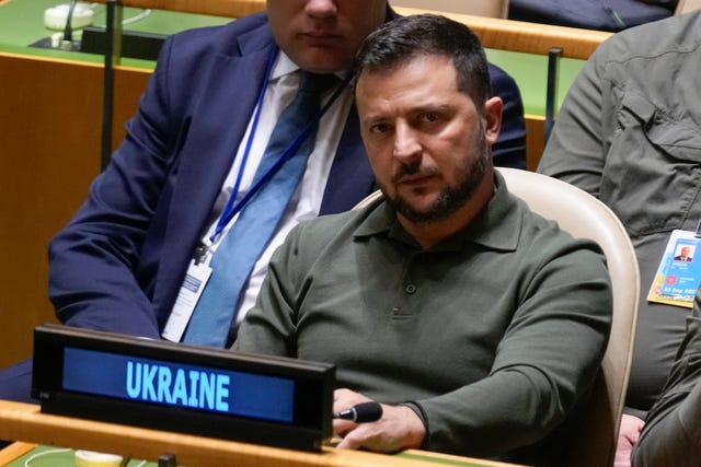 Ukrainian President Volodymyr Zelensky listens to speakers