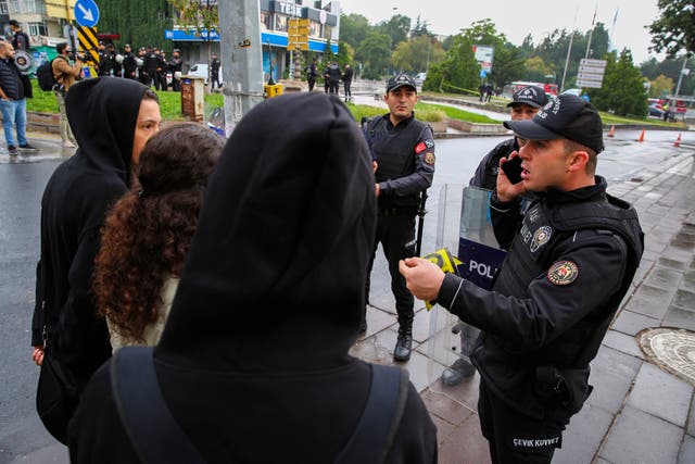 Turkish police talk to passers-by after the explosion in Ankara on Sunday