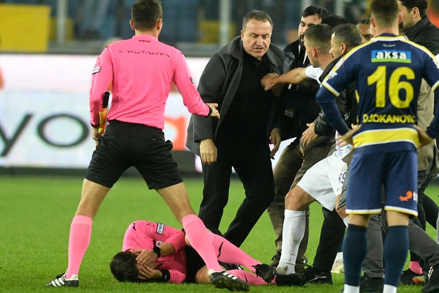 Meler holds his face as he lies on the ground after being punched by Koca, center, on Monday