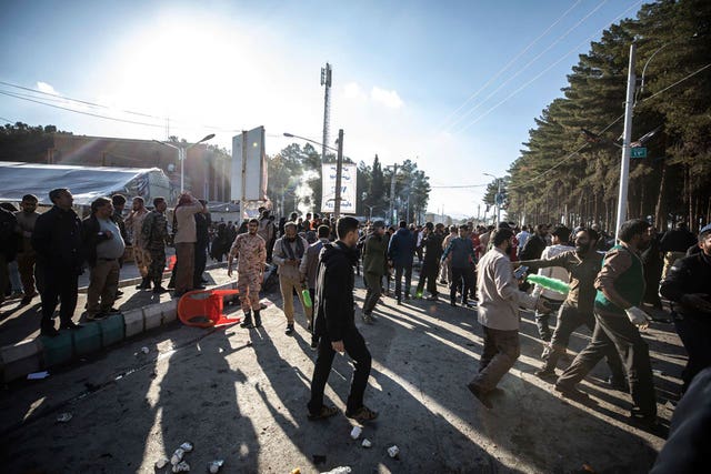 People look on after an explosion in Kerman