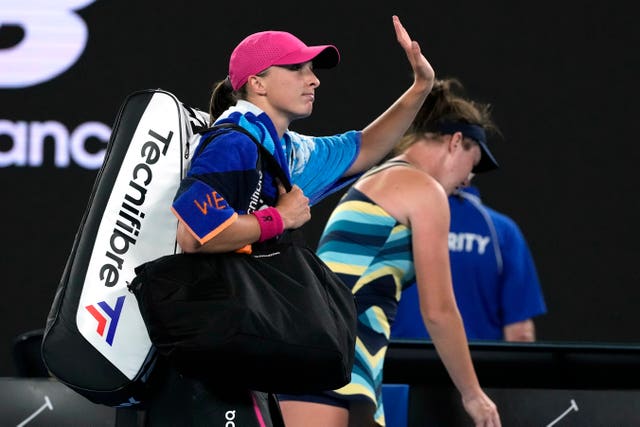 Iga Swiatek waves as she leaves Rod Laver Arena