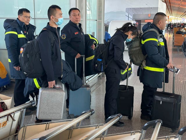 Rescue workers prepare to board a flight to Xinjiang from Beijing Capital International Airport in Beijing on Tuesday