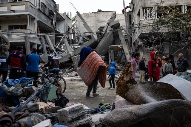 Palestinians inspect the damage of residential buildings after an Israeli air strike in Rafah