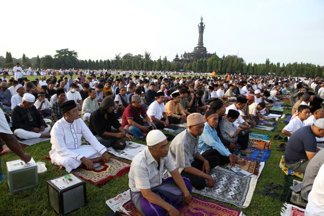 Muslims perform prayers marking the end of the holy fasting month of Ramadan at a field in Bali 