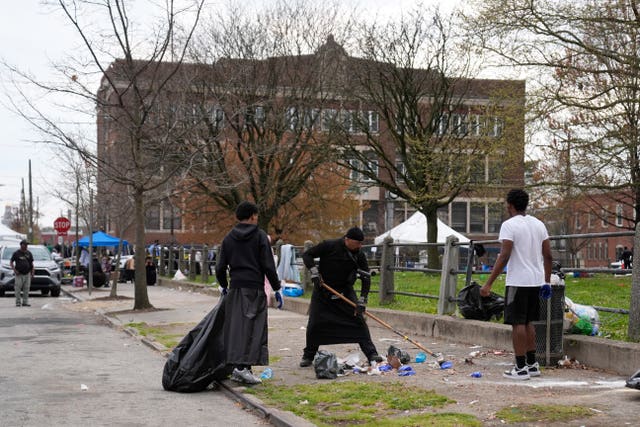 People clean up debris at the scene of a shooting at an Eid al-Fitr event in Philadelphia