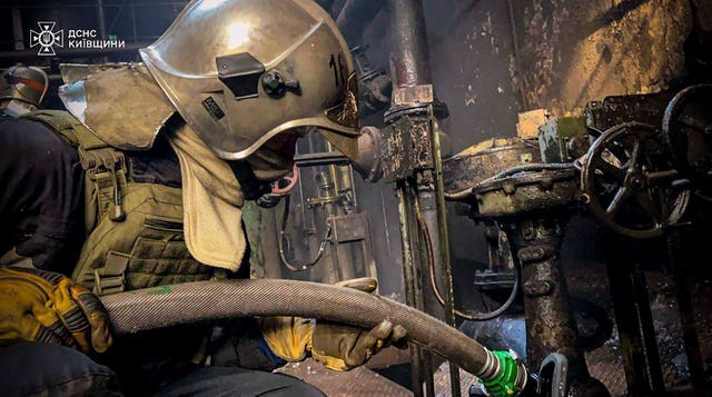 In this photo provided by the Ukrainian Emergency Service, an emergency worker extinguishes a fire after a Russian attack on the Trypilska thermal power plant