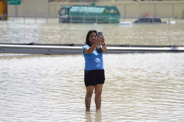 A woman takes a selfie in floodwater in Dubai