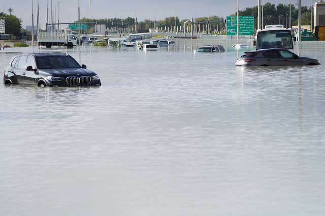 Vehicles sit abandoned in floodwater covering a major road in Dubai