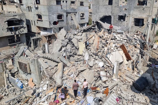 Palestinians look at the destruction after an Israeli air strike in Rafah 
