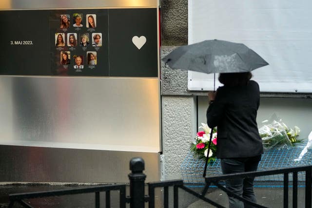 Woman stands next to memorial