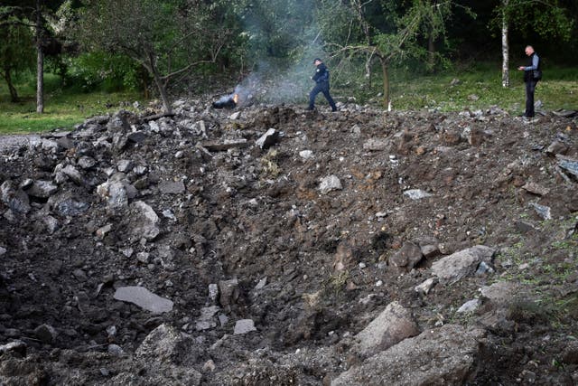 Police officers inspect a crater after a Russian missile attack in Zaporizhzhia, Ukraine 