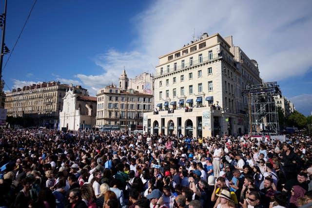 People wait ahead of the arrival of the Belem, the three-masted sailing ship which is carrying the Olympic flame, in Marseille, southern France